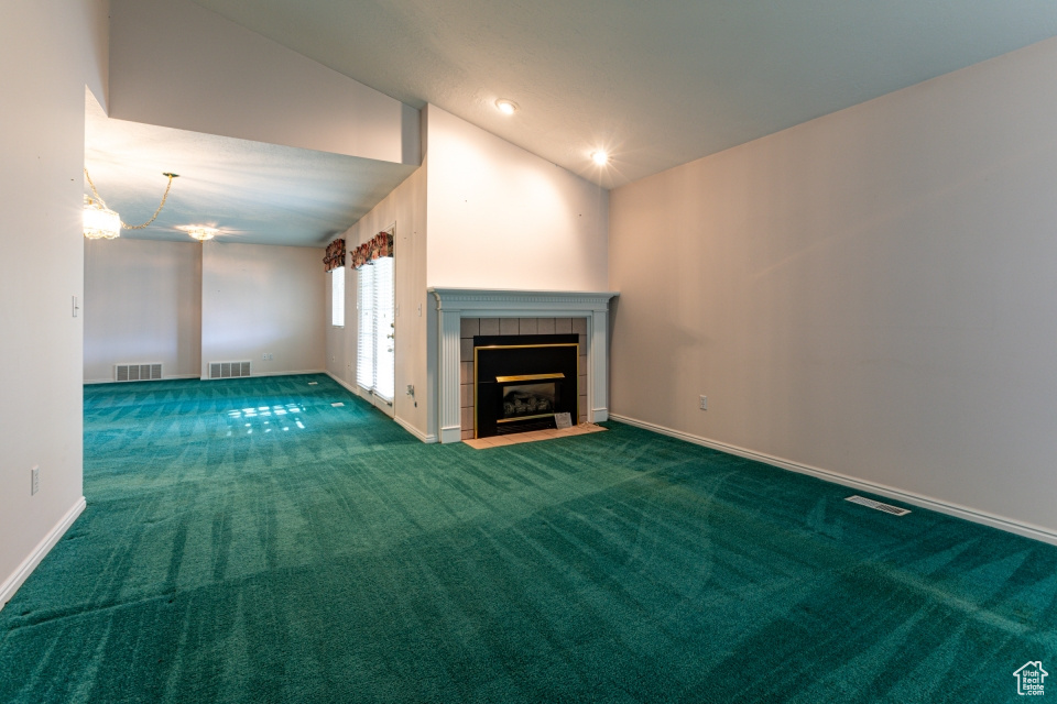 Unfurnished living room featuring a chandelier, visible vents, carpet, and a fireplace