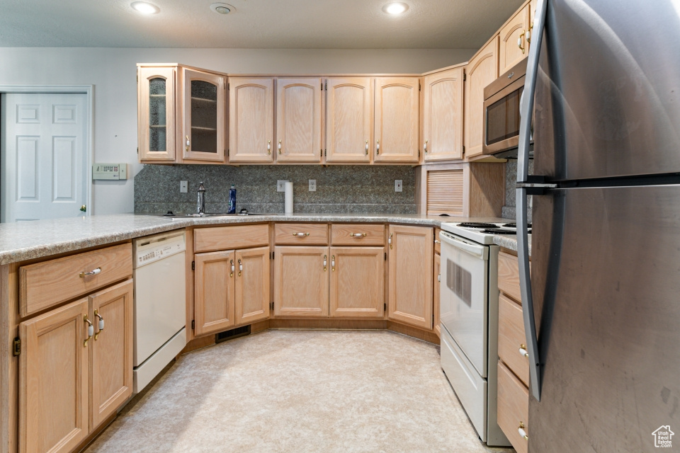 Kitchen featuring a sink, light brown cabinetry, and stainless steel appliances