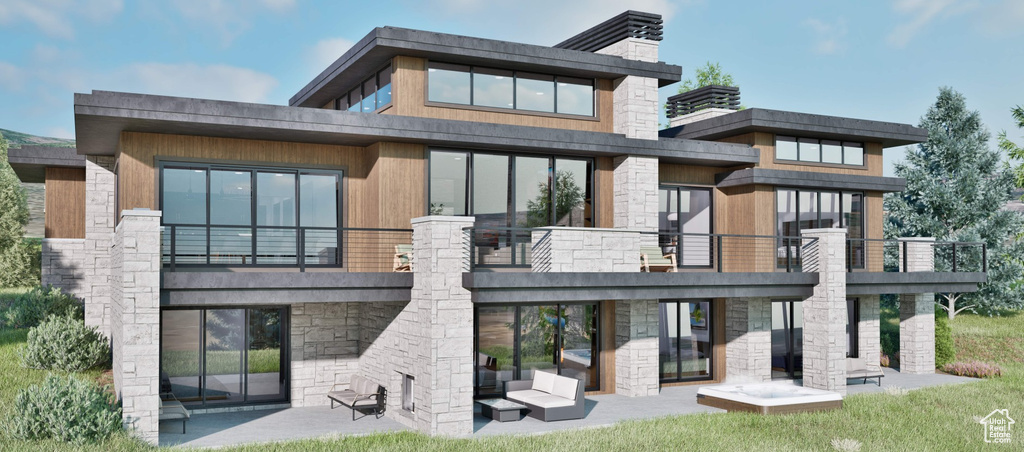 Rear view of house featuring stone siding, a patio area, and a balcony