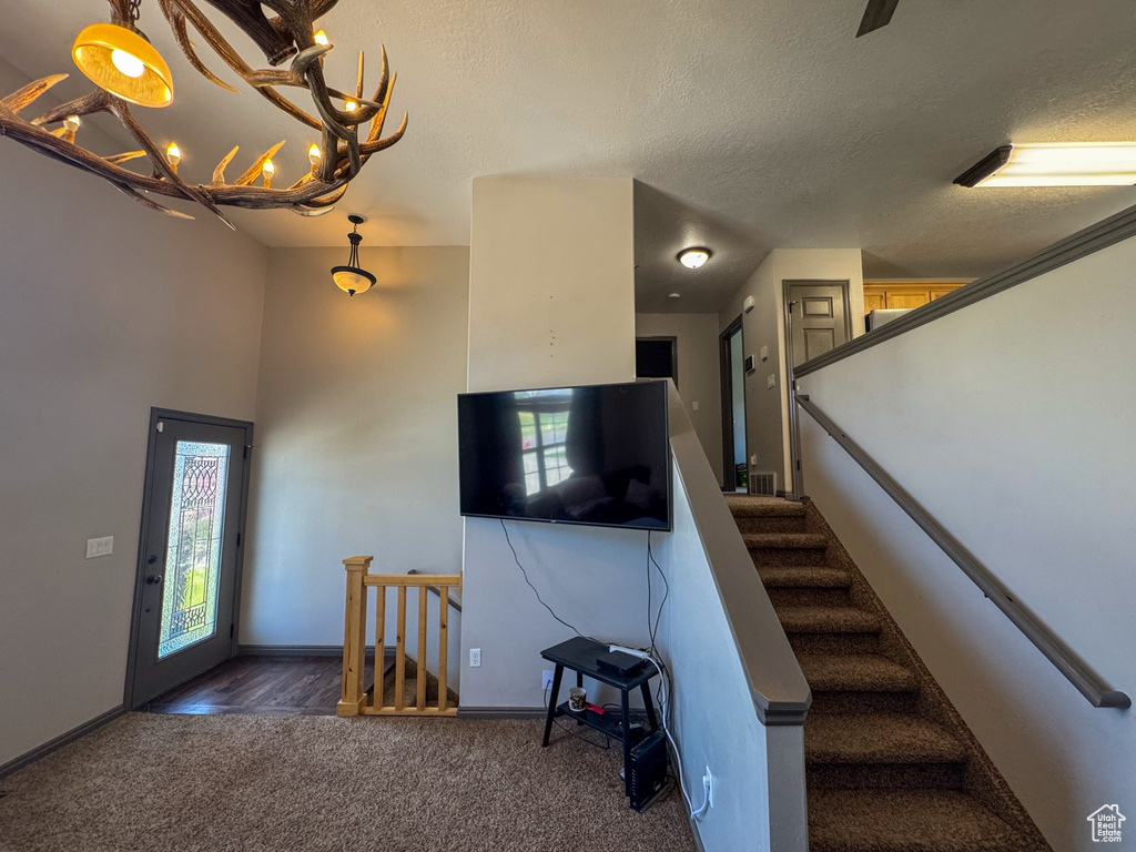 Stairway featuring baseboards, a textured ceiling, and carpet