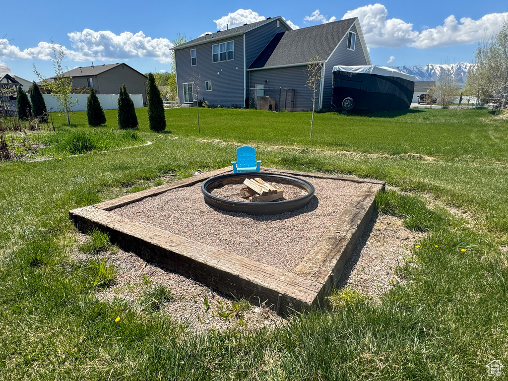 View of yard with fence and a fire pit