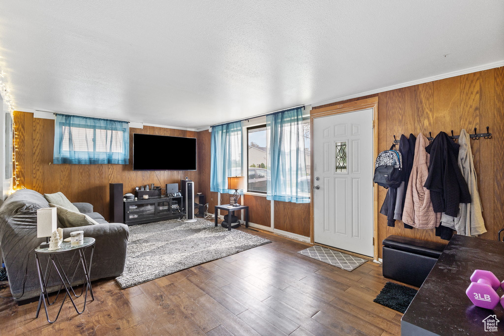 Living area with wooden walls, wood finished floors, and a healthy amount of sunlight