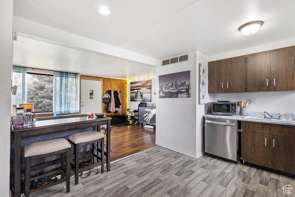 Kitchen with a sink, dark brown cabinets, stainless steel appliances, and visible vents