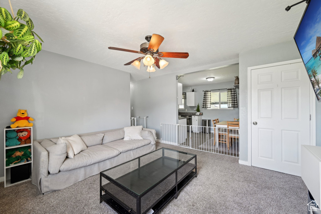 Living room with carpet floors and ceiling fan