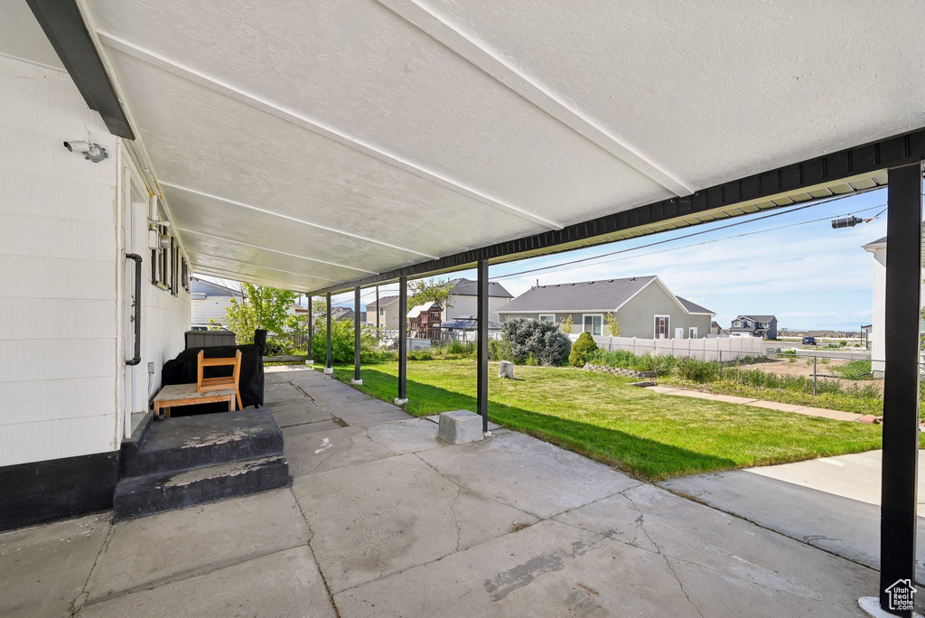 View of patio featuring fence and a residential view