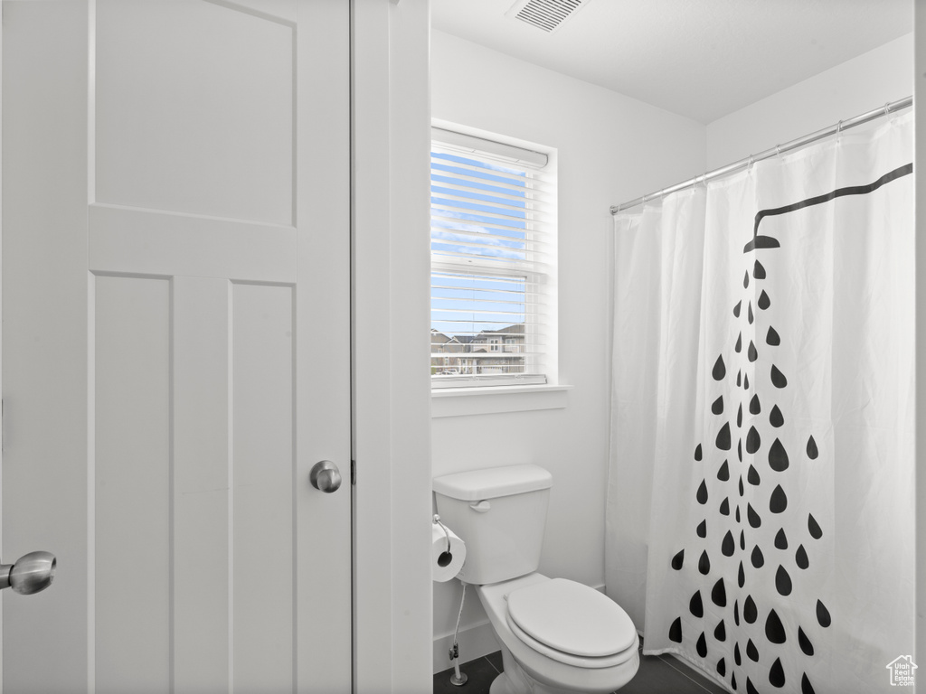 Bathroom with toilet, baseboards, visible vents, and a shower with shower curtain