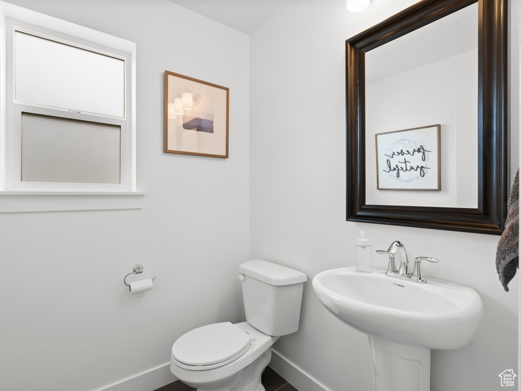 Bathroom with toilet, baseboards, and a sink