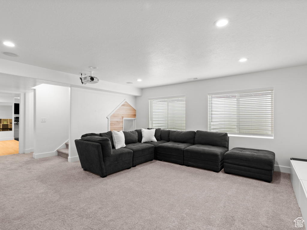 Living area featuring stairs, recessed lighting, and light colored carpet