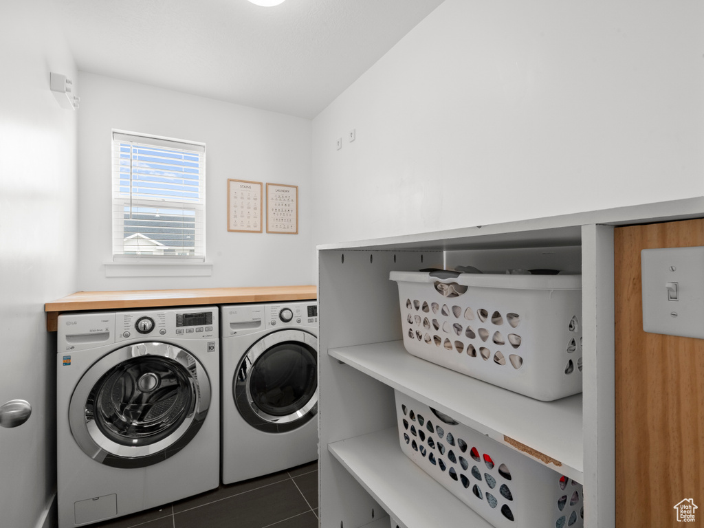 Clothes washing area with tile patterned flooring, laundry area, and washer and clothes dryer