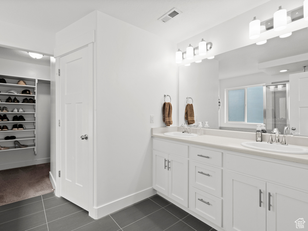 Bathroom with a sink, tile patterned floors, double vanity, and visible vents