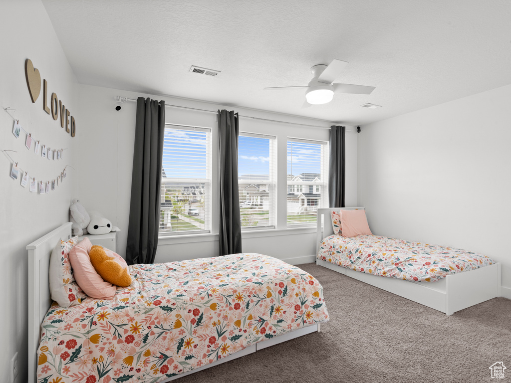 Bedroom with carpet floors, baseboards, a ceiling fan, and visible vents