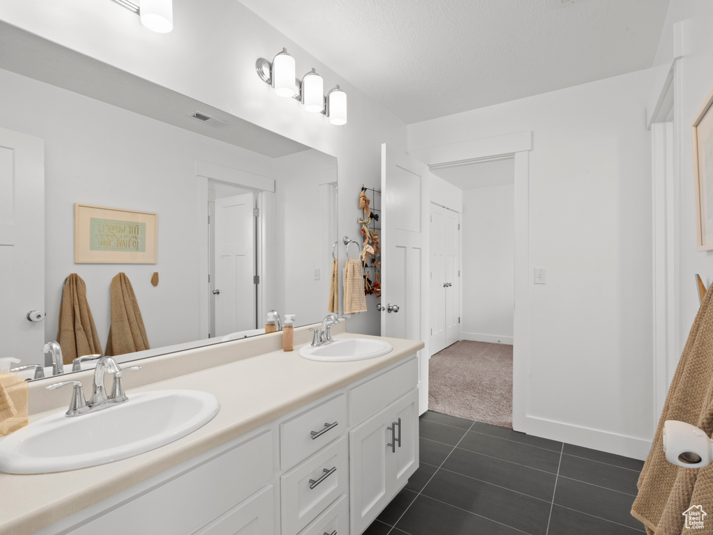 Full bathroom with a sink, tile patterned floors, double vanity, and visible vents