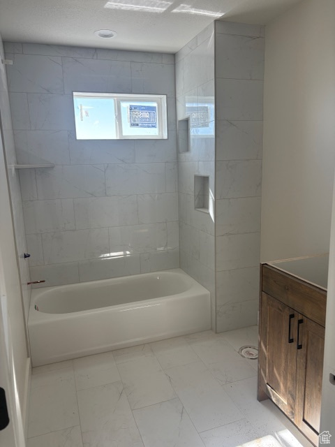 Bathroom featuring marble finish floors, tub / shower combination, and vanity
