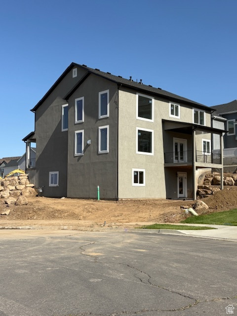 View of home\'s exterior with stucco siding and a balcony