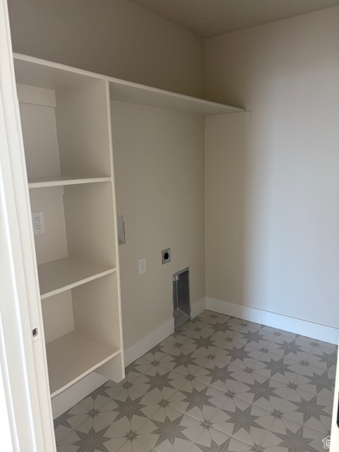 Washroom with light flooring, hookup for an electric dryer, and baseboards