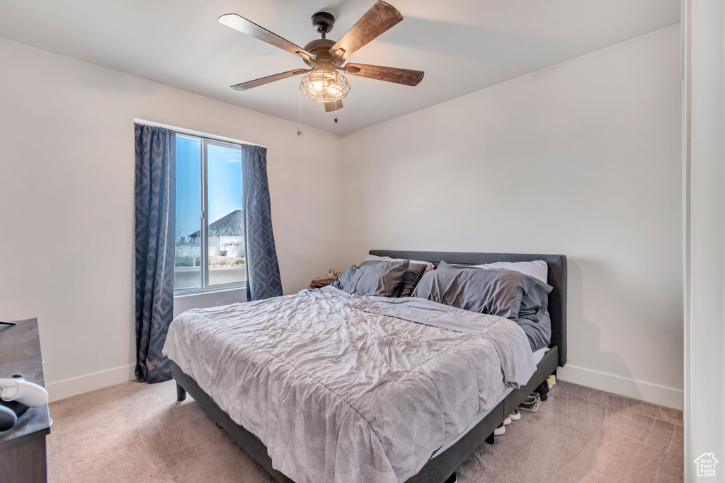 Bedroom with baseboards, ceiling fan, and light carpet