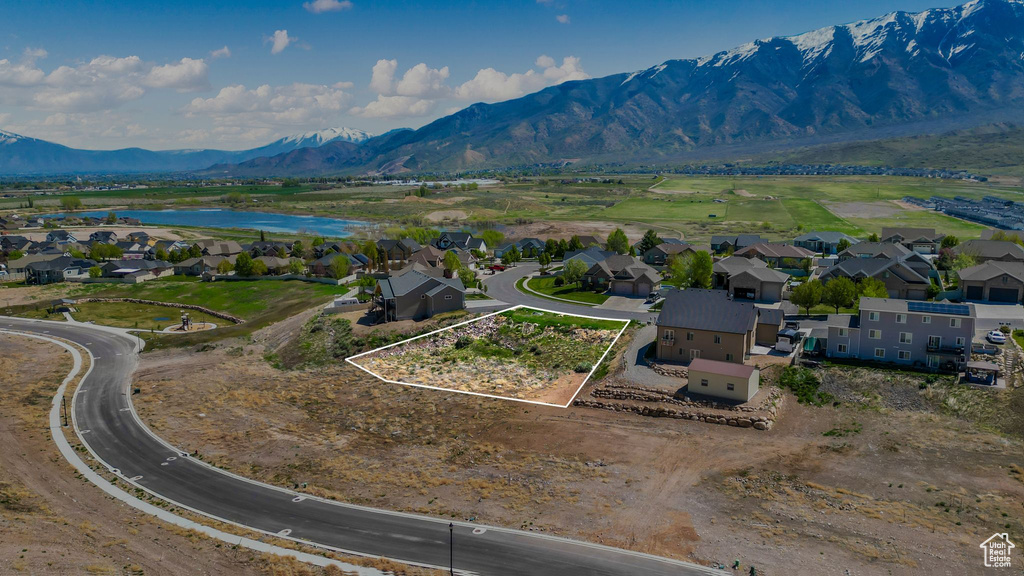 Birds eye view of property featuring a water and mountain view and a residential view