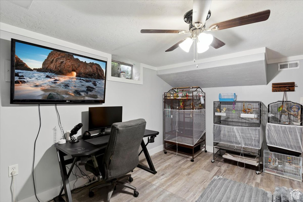 Office area featuring a textured ceiling, ceiling fan, wood finished floors, and visible vents