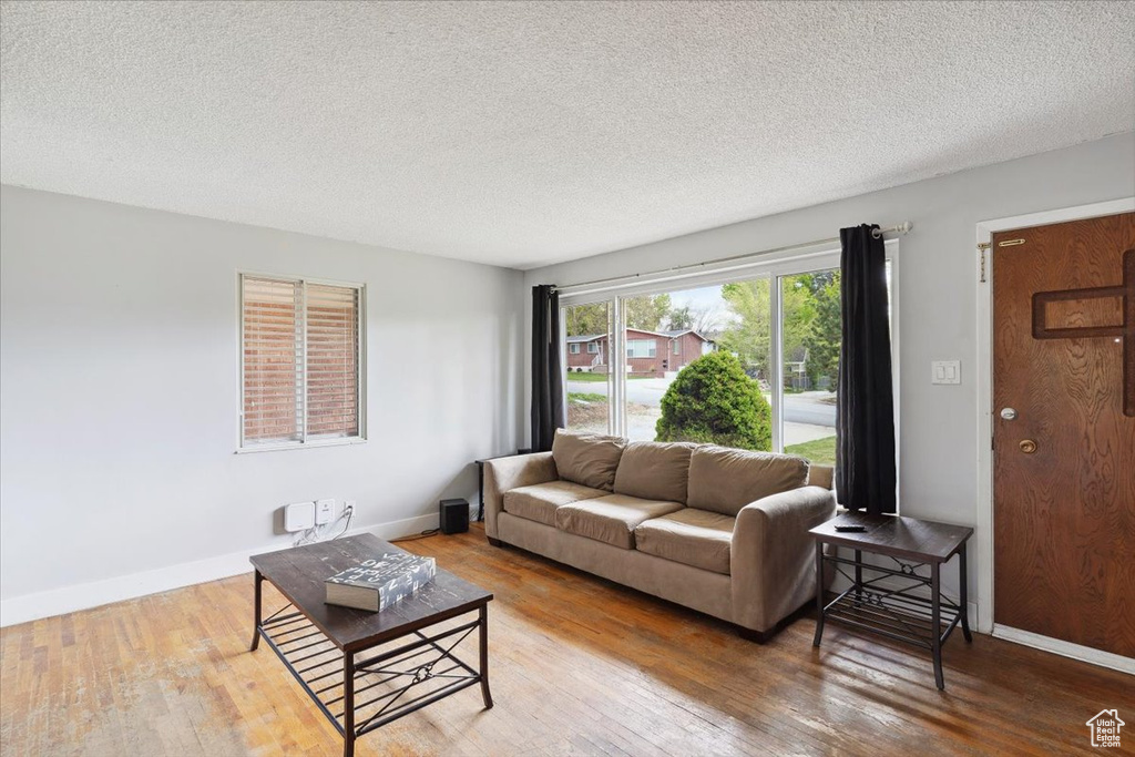 Living room with a textured ceiling and wood finished floors