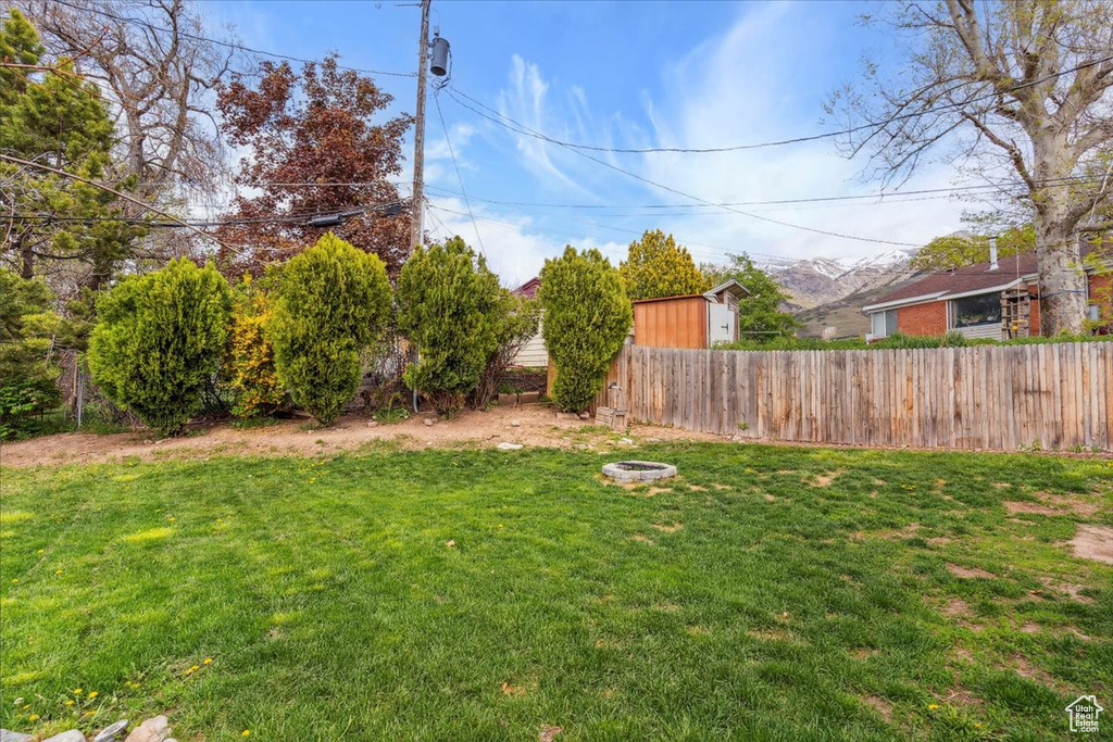 View of yard with fence and a fire pit