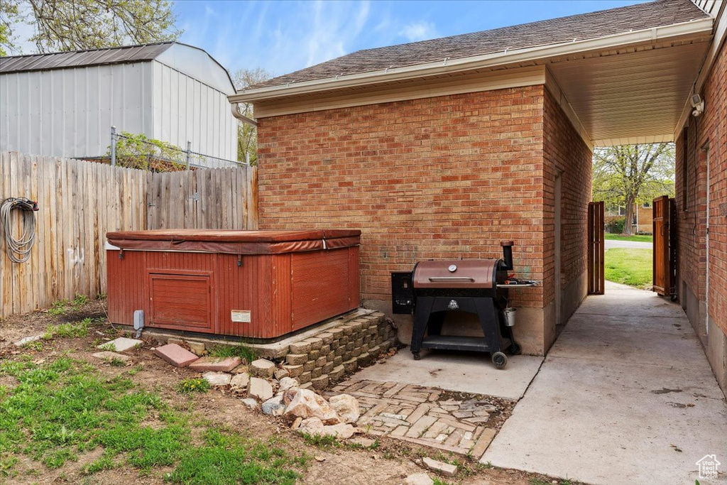 View of patio / terrace with fence and a hot tub