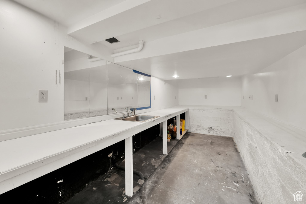 Interior space featuring vanity, concrete floors, and a workshop area