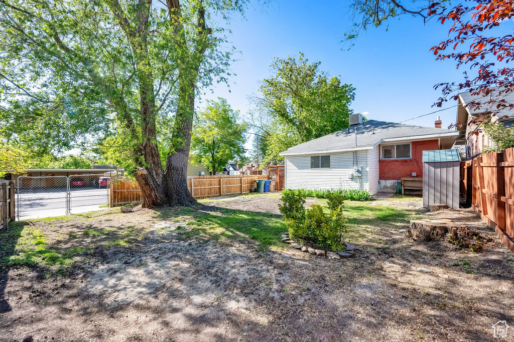 View of yard with a fenced backyard and a shed