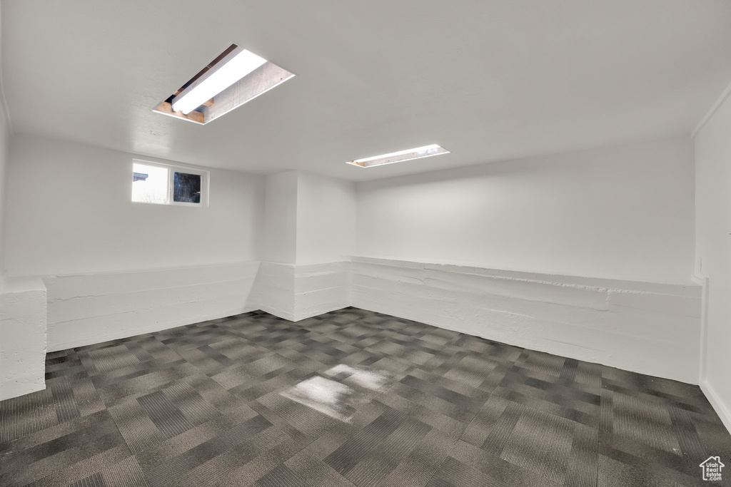Below grade area featuring dark colored carpet