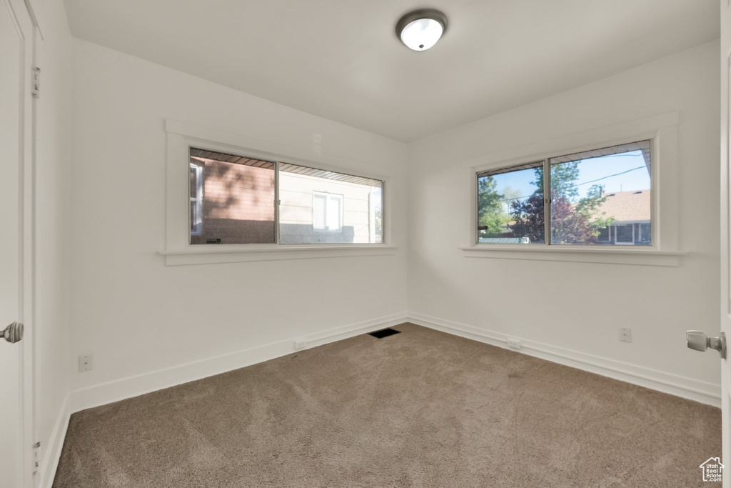 Carpeted empty room with baseboards