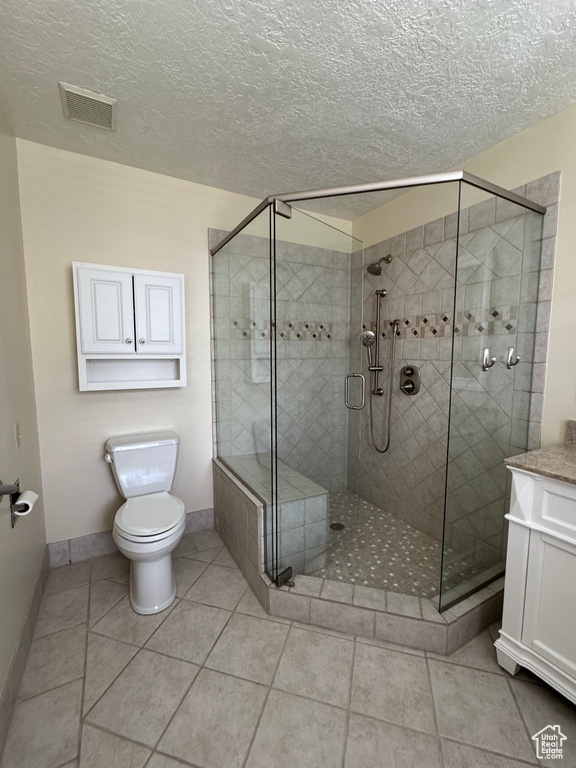 Bathroom featuring a shower stall, toilet, and visible vents