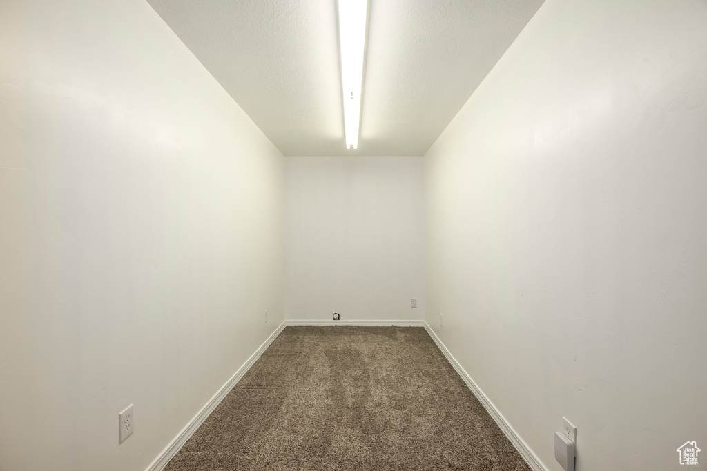 Carpeted spare room featuring baseboards