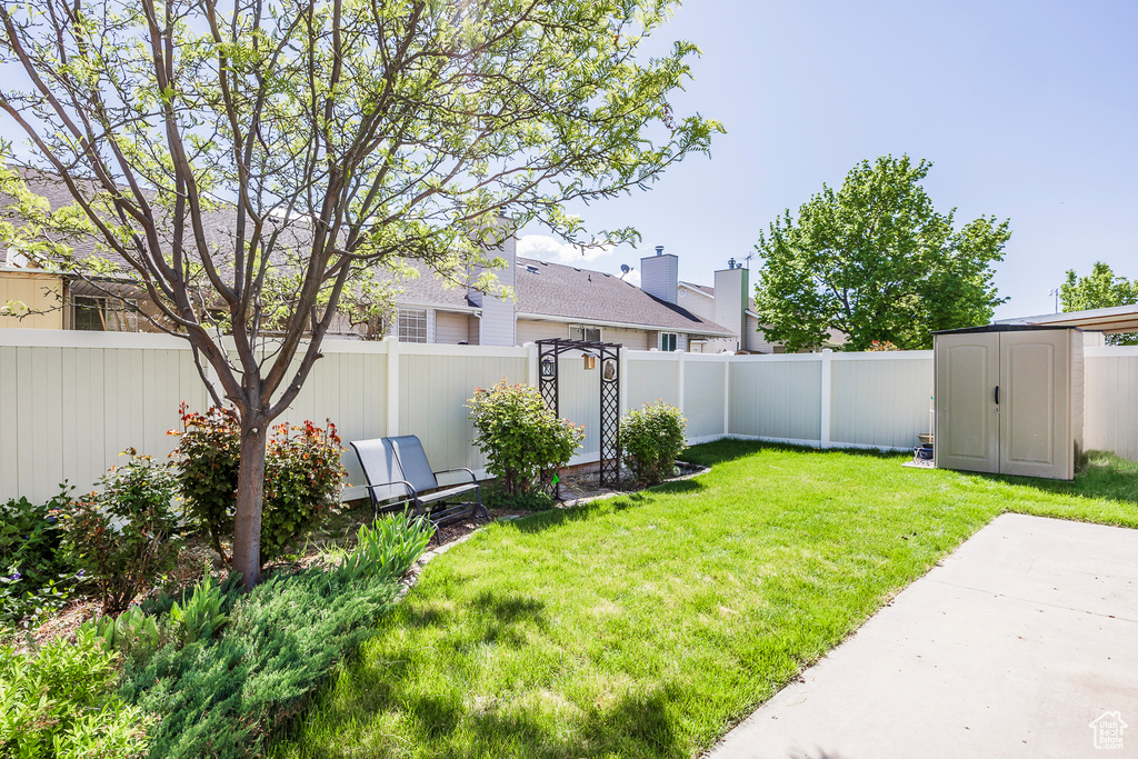 View of yard with a fenced backyard, an outdoor structure, and a shed