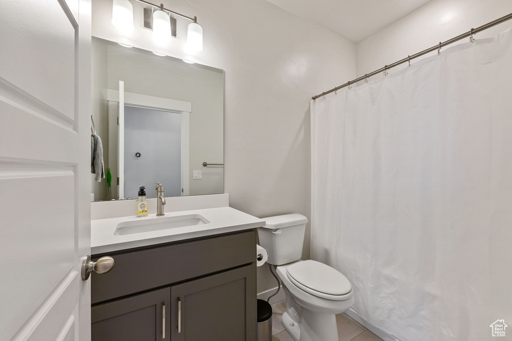 Full bath featuring toilet, tile patterned flooring, and vanity