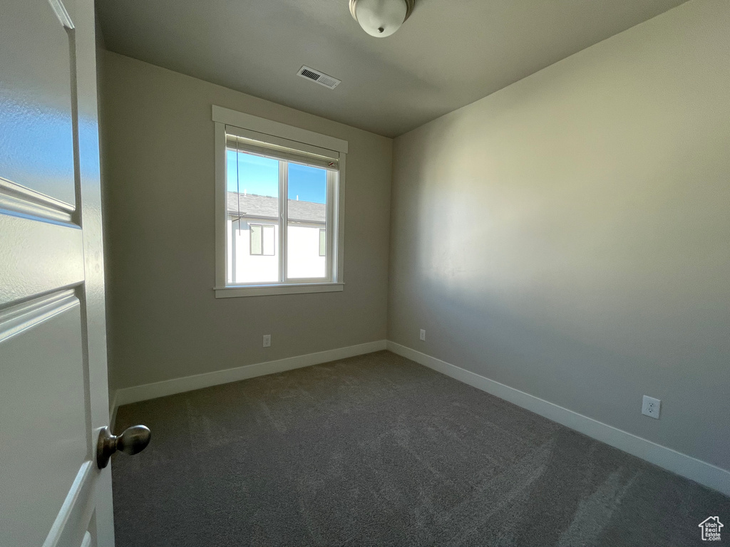 Spare room featuring carpet and baseboards