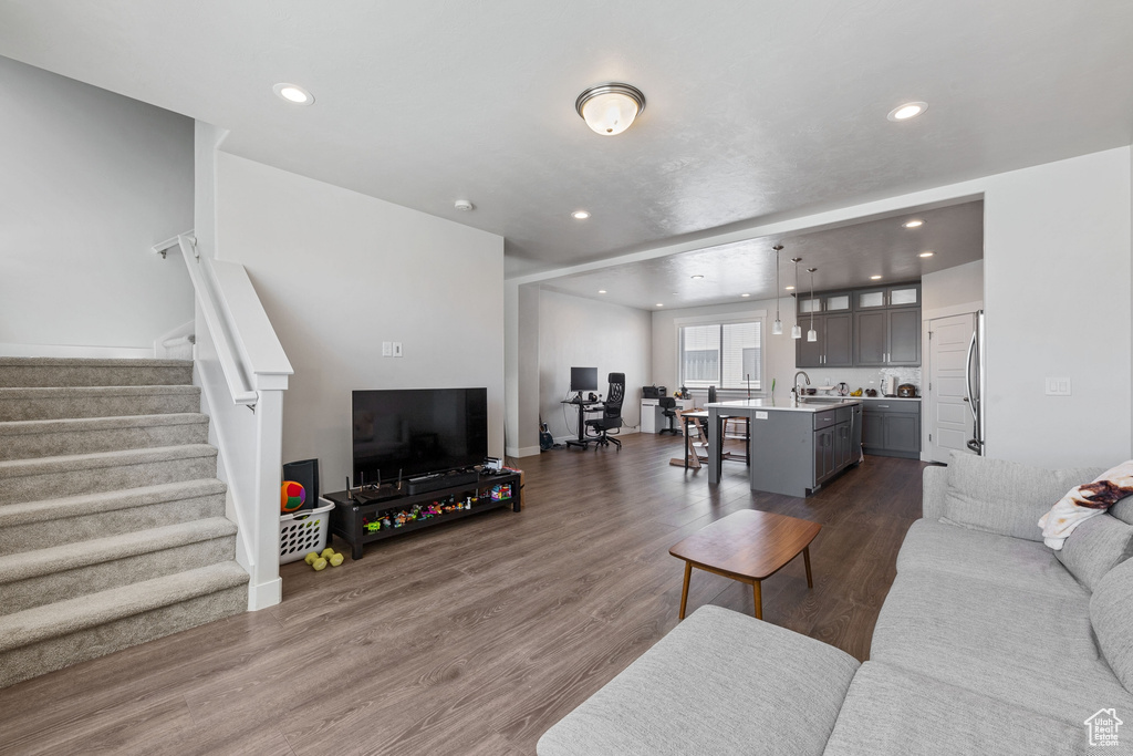 Living area featuring recessed lighting, dark wood-style floors, and stairway