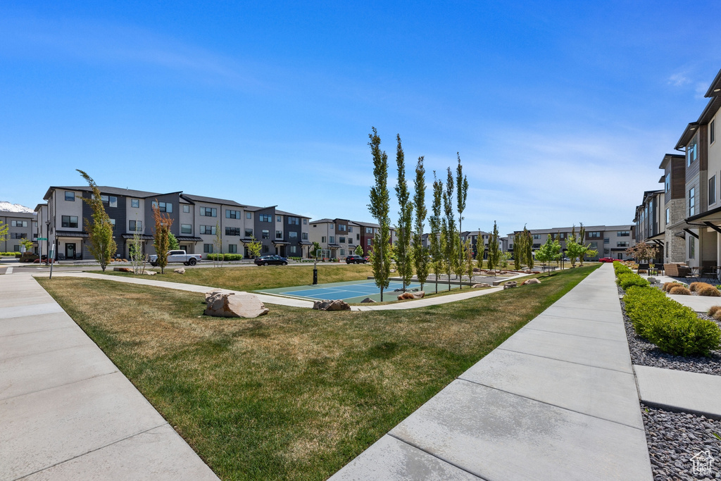 View of property\'s community with a lawn, community basketball court, and a residential view