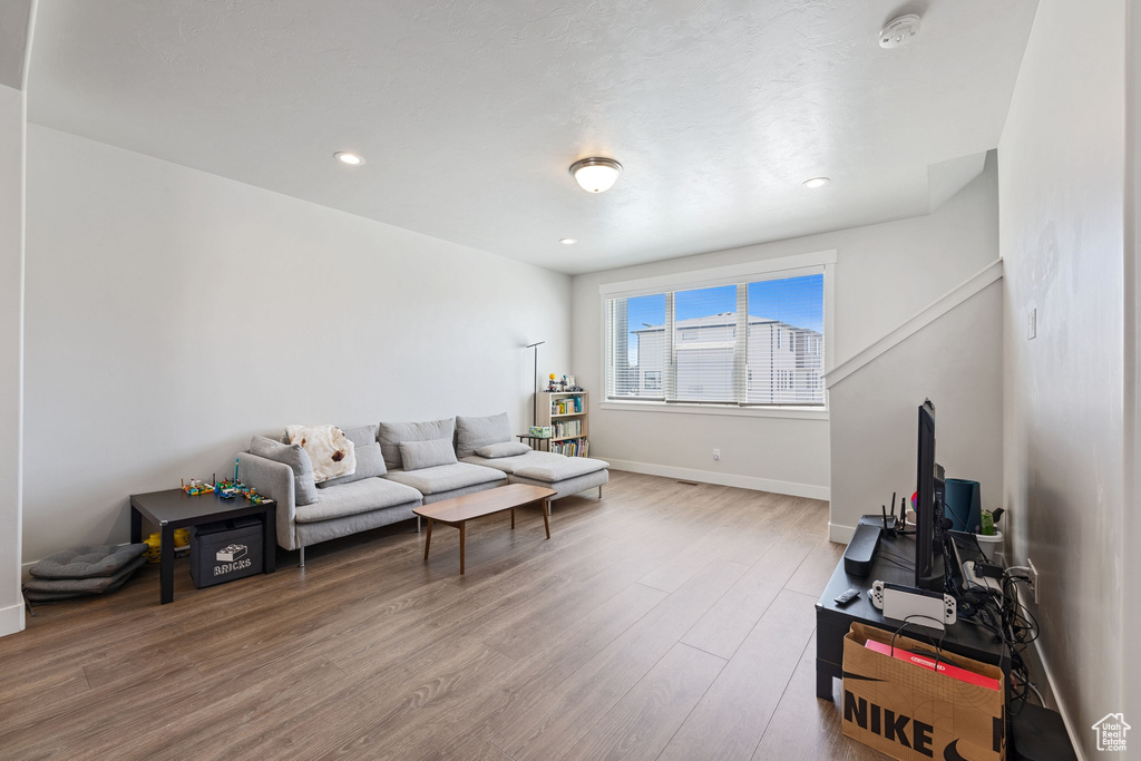 Living room with baseboards, recessed lighting, and wood finished floors
