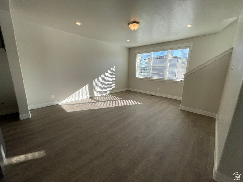 Unfurnished living room with wood finished floors, baseboards, and recessed lighting