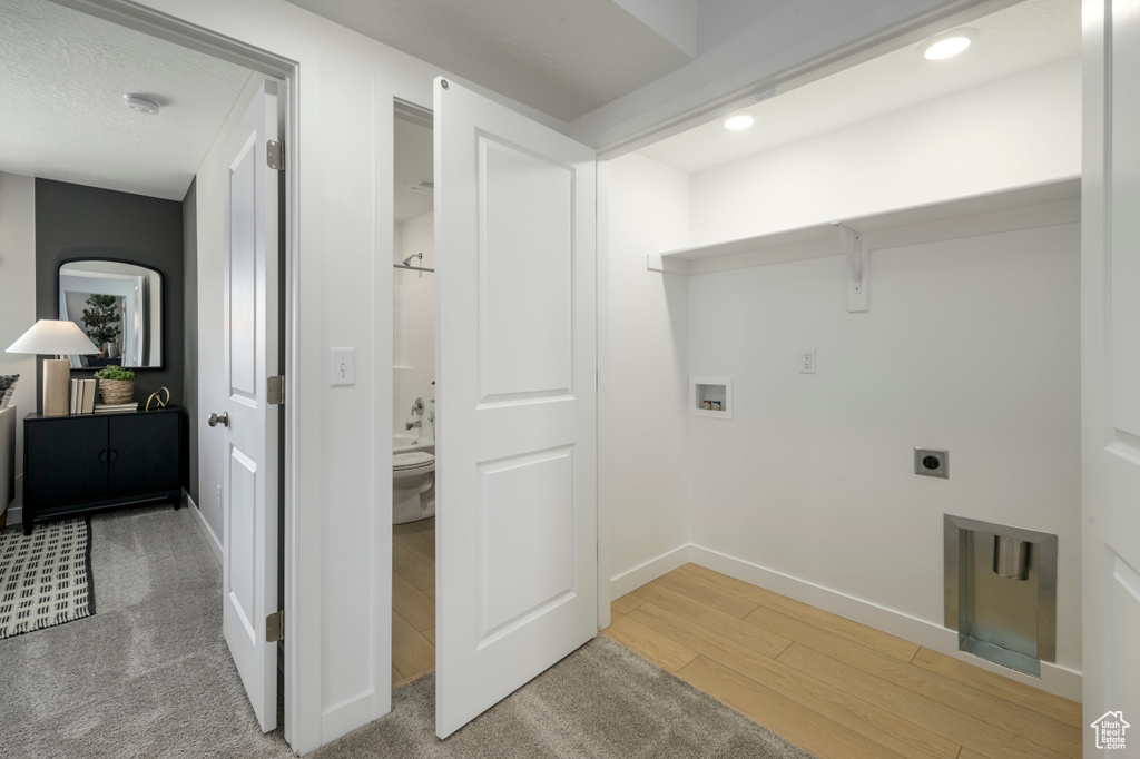 Laundry room with laundry area, hookup for a washing machine, recessed lighting, wood finished floors, and hookup for an electric dryer