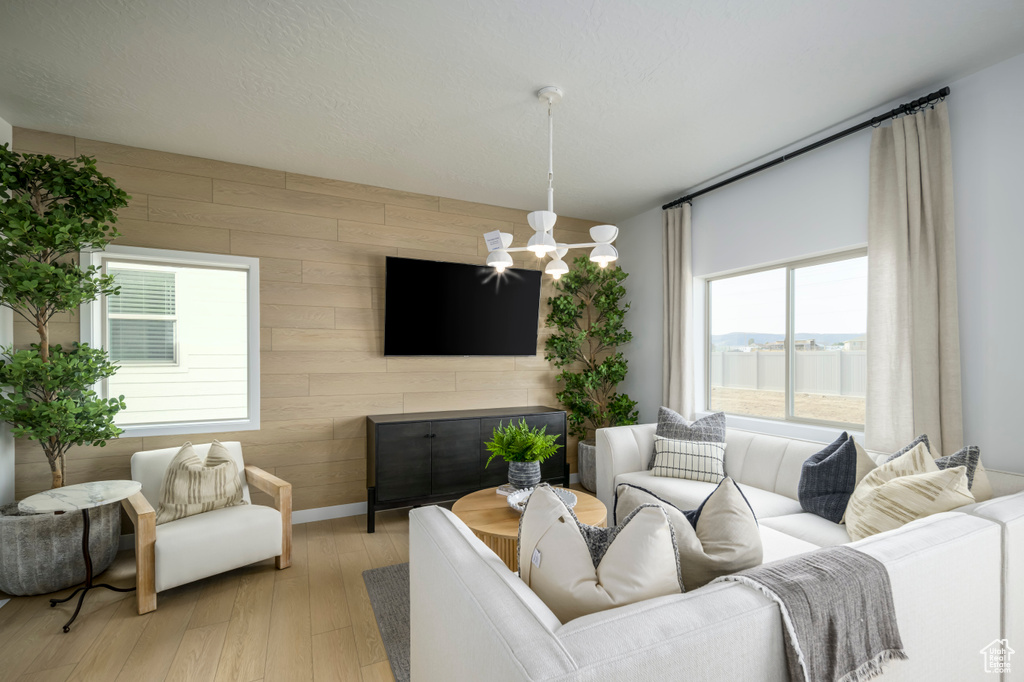 Living area with wooden walls, baseboards, and light wood finished floors