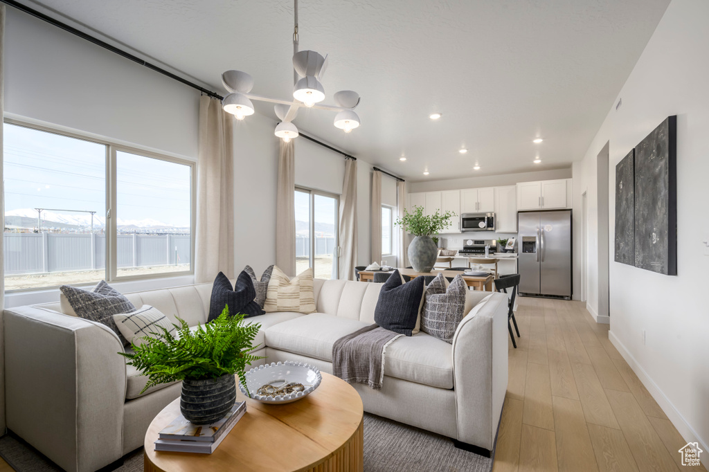 Living room with recessed lighting, baseboards, and light wood-style flooring