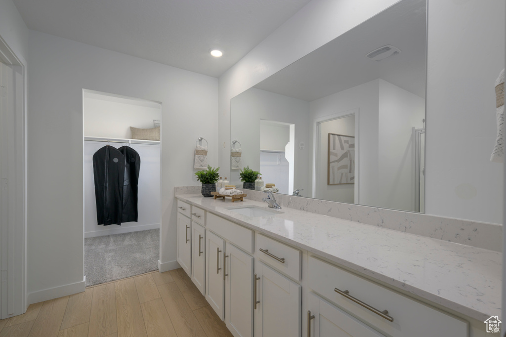 Full bath featuring recessed lighting, baseboards, wood finished floors, and vanity
