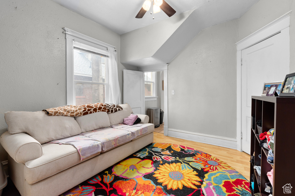 Living area featuring a ceiling fan, baseboards, and light wood finished floors
