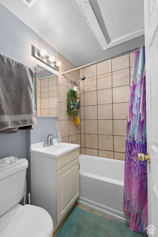 Full bathroom with toilet, shower / bath combo with shower curtain, and vanity