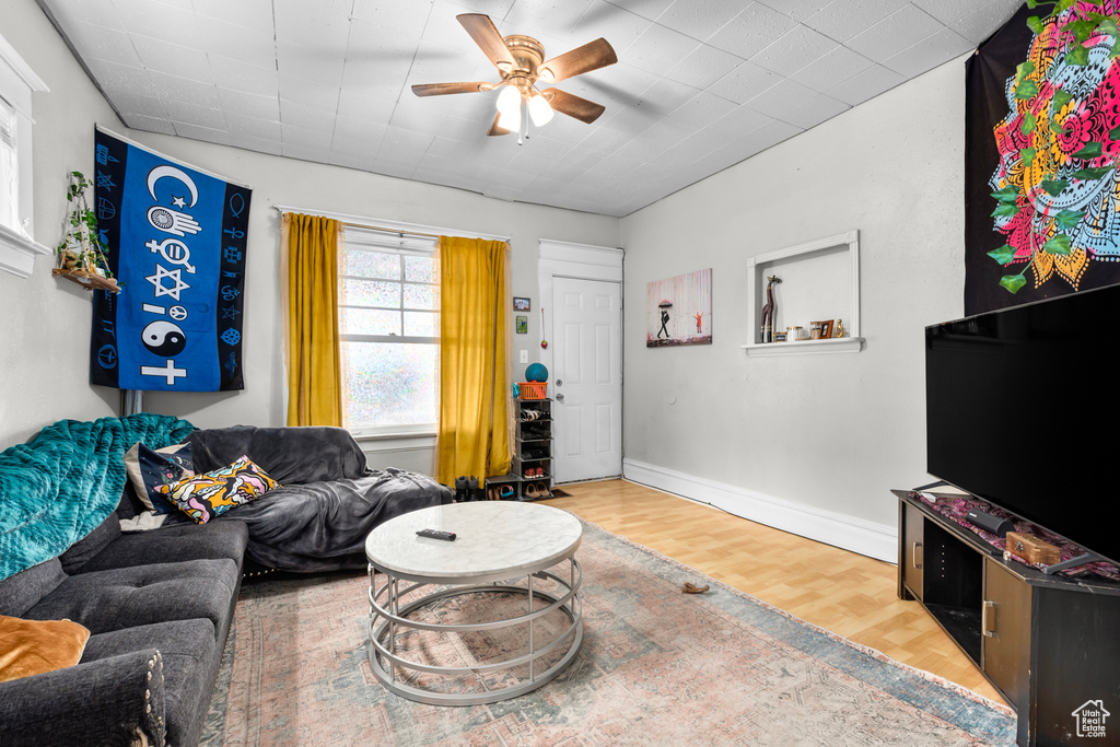 Living area featuring baseboards, ceiling fan, and wood finished floors