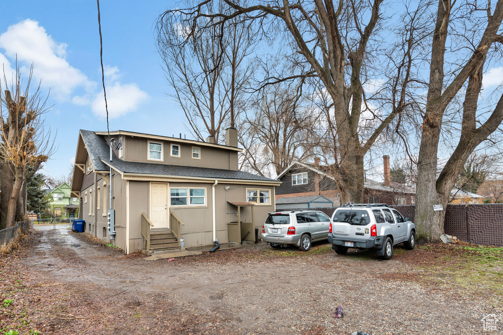 View of front of property featuring fence, a chimney, a shingled roof, and entry steps