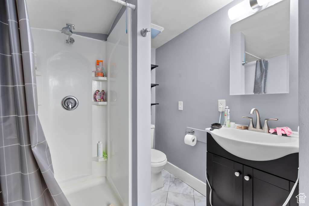 Full bathroom with vanity, marble finish floor, toilet, baseboards, and a shower with curtain