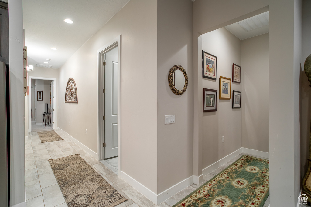 Corridor with baseboards and recessed lighting