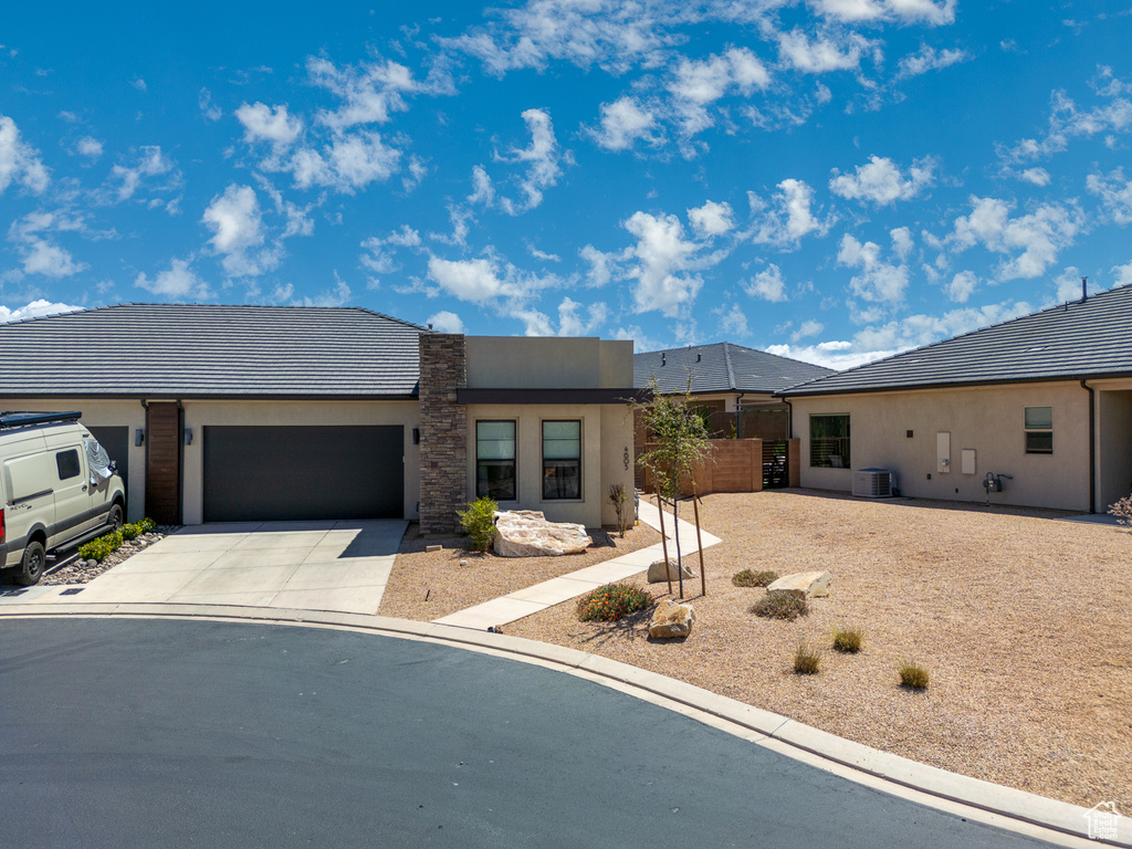 Ranch-style home featuring central AC unit, a garage, fence, concrete driveway, and stucco siding
