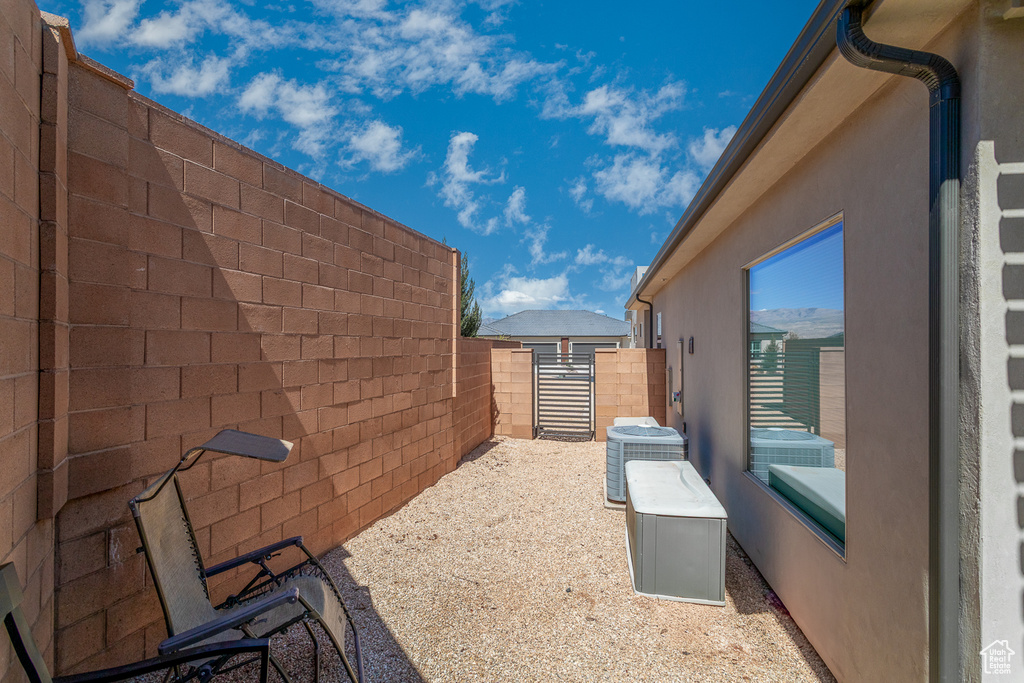 View of property exterior featuring fence, central AC unit, and stucco siding